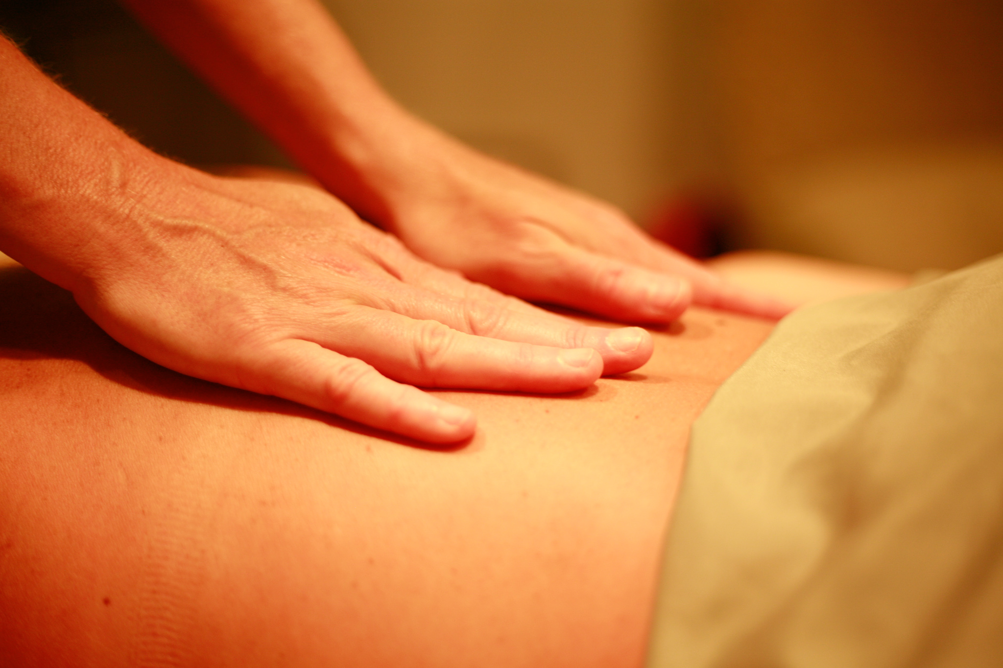 Hands on client's back massaging